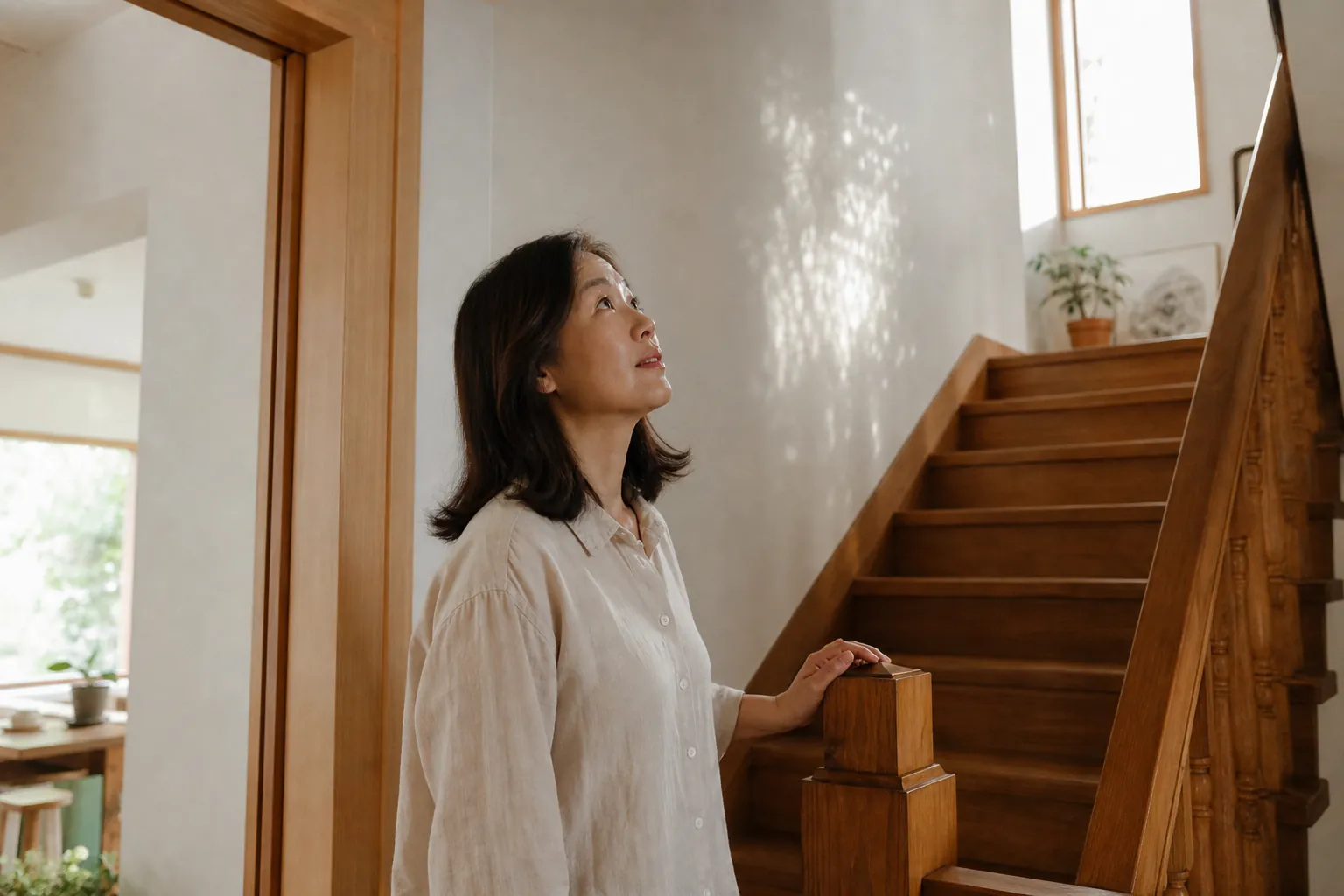 실내 계단 아래에서 위층을 올려다보며 구조를 살피는 모습 (연출 예시)